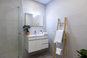 a white bathroom with a sink and a shower at Live in Aveiro in Aveiro