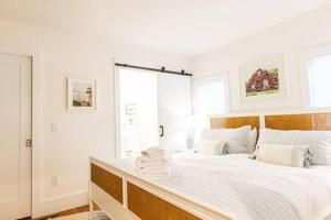 Un dormitorio blanco con una cama con toallas. en Walk to Joshua Pond Beach & Downtown, en Barnstable