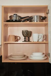 a shelf with pots and pans and plates in a kitchen at Florina Modern Studio in Florina