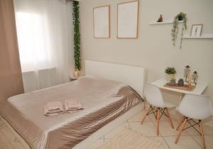 a bedroom with a bed and a desk with two towels at Florina Modern Studio in Florina