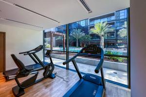 a gym with two cardio machines and a large window at Cityscape lofts Living in City Walk 2BR Unit in Dubai