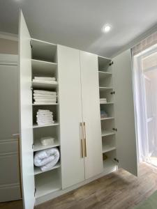 a white walk in closet with white cabinets at Highvill Ishim 412 in Astana