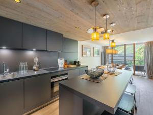 a kitchen with black cabinets and a large island at Appartement Courchevel 1550, 4 pièces, 9 personnes - FR-1-562-75 in Courchevel
