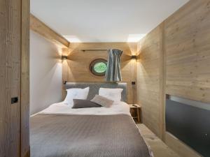 a bedroom with a large bed with wooden walls at Appartement Courchevel 1550, 4 pièces, 9 personnes - FR-1-562-75 in Courchevel