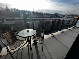 een tafel en stoelen op een balkon met uitzicht bij City Center Apartments z parkingiem in Bydgoszcz