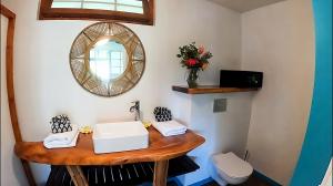 a bathroom with a sink and a mirror at Fare Oviri Lodge in Opoa