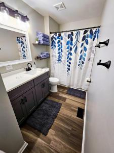 een badkamer met een wastafel, een toilet en een douchegordijn bij Beautifully renovated 4bed/2bath home - Pets OK in Aurora