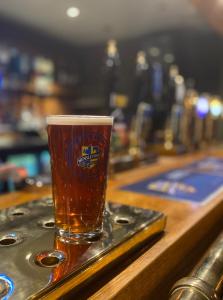 a glass of beer sitting on a tray on a bar at Middle House in Askrigg