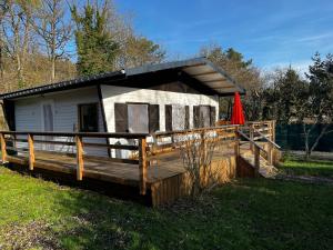 a small cabin with a deck and a red umbrella at Une expérience inoubliable dans un refuge magique offrant détente et bien-être garantie in Rochefort