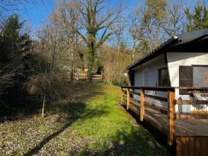 a cabin with a wooden fence next to a yard at Une expérience inoubliable dans un refuge magique offrant détente et bien-être garantie in Rochefort