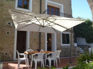 - une table et des chaises sous un parasol sur la terrasse dans l'établissement Belvilla by OYO Ventimiglia, à Vintimille