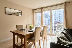 uma sala de jantar com uma mesa de madeira e cadeiras em Vieux Lille - Superb apartment balcony parking! em Lille