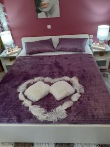 ein Bett mit zwei herzförmigen Kissen in der Unterkunft DreamHouse in Nafpaktos