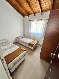 a bedroom with two beds and a window at Villa Simona in Santa Rosa de Calamuchita +18 photos
