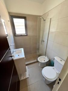 a bathroom with a toilet and a sink and a shower at Villa Simona in Santa Rosa de Calamuchita
