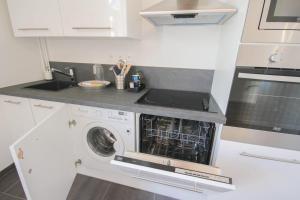 a kitchen with a washing machine and a sink at Vieux Lille: bright, functional apartment in Lille