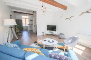 een woonkamer met een blauwe bank en een tafel bij Vieux Lille: bright, functional apartment in Lille