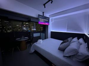 um quarto com uma cama e uma televisão por cima. em Ap Luxo Jardins Cd 1714 em São Paulo