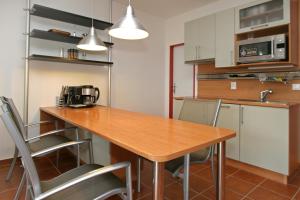 a kitchen with a wooden table and chairs at Apartmány DOKY Holiday in Lipno nad Vltavou