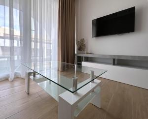 a living room with a glass table and a tv at Miami Apartments in St. Julianʼs
