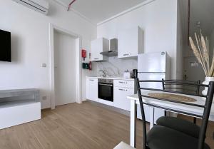 a kitchen with white appliances and a table with a chair at Miami Apartments in St. Julianʼs