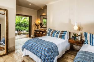 a bedroom with two beds and a mirror at Hidden All inclusive House in Punta Mita in Punta Mita