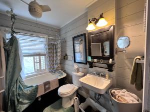 La salle de bains est pourvue d'un lavabo, de toilettes et d'une baignoire. dans l'établissement The Coziest Cottage in Waxahachie, à Waxahachie
