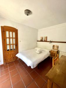 1 dormitorio con 2 camas, mesa de madera y sidra de mesa en Habitación con baño privado, en Granada