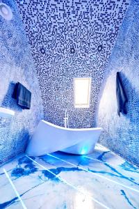 a bathroom with a white tub in a blue room at Domeparty - лучшая локация для вечеринок in Petropavlovskaya Borshchagovka