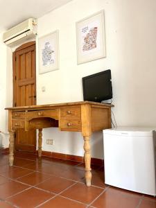 un escritorio de madera con TV encima en Habitación con baño privado, en Granada