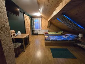 ein Schlafzimmer mit einem Bett und einem Schreibtisch im Dachgeschoss in der Unterkunft JASTRZĄB in Ropienka