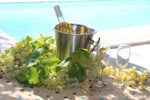 Ein Haufen Trauben und Weingläser auf dem Tisch. in der Unterkunft Cottage romantique avec piscine privée au Vallon des Etoiles in Lussas