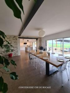una grande sala da pranzo con un lungo tavolo e sedie di Le Petit Loup grande maison de charme en campagne a LʼOie