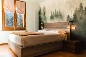 - une chambre avec un lit orné d'une grande peinture murale dans l'établissement Maison Poluc hotel apartments, à Champoluc