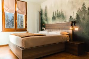a bedroom with a bed with a large painting on the wall at Maison Poluc hotel apartments in Champoluc