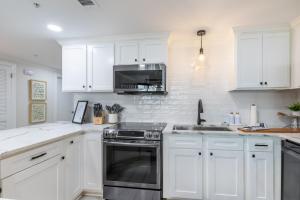 una cucina bianca con fornelli e microonde di Phoenix X 1403 condo a Orange Beach Altre 58 foto