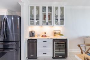 una cucina con mobili bianchi e un frigorifero in acciaio inossidabile di Phoenix X 1403 condo a Orange Beach