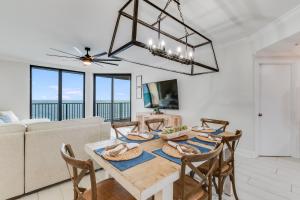 una sala da pranzo con tavolo, sedie e lampadario pendente di Phoenix X 1403 condo a Orange Beach
