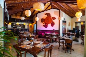 un restaurante con mesas y sillas y un osito de peluche en la pared en Hotel & Spa Poco a Poco - Costa Rica en Monteverde Costa Rica