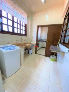 een badkamer met een wastafel en een wasmachine bij Apartamento com vista panorâmica in João Monlevade