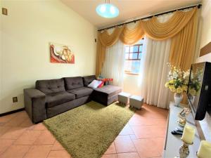 een woonkamer met een bank en een tapijt bij Apartamento com vista panorâmica in João Monlevade
