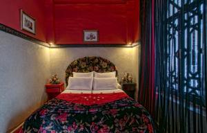 Schlafzimmer mit einem Bett mit roter Decke in der Unterkunft RIAD DREAMS in Marrakesch