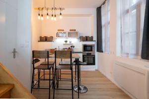 małą kuchnię ze stołem i krzesłami w pokoju w obiekcie Unique 3 bed house in Old Lille! w Lille