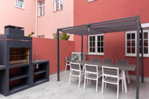 un patio avec une table et des chaises à côté d'un bâtiment dans l'établissement Dellarose Max, à Porto