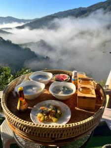 a table with plates of food on top of a mountain at แตะขอบฟ้าสะปัน โฮมสเตย์ in Ban Huai Ti
