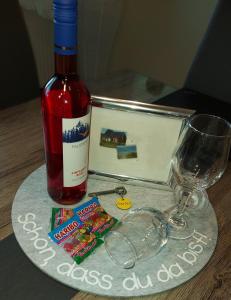 una botella de vino y copas en una mesa en Ferienhaus Lachmöwe, en Fehmarn