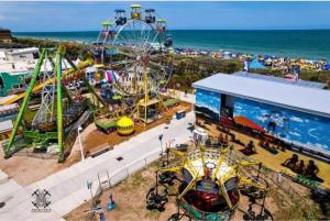 un parque de atracciones con una noria y un carnaval en Beachfront-Boardwalk-Elevator-Pool-Free Parking for 2 Cars! en Carolina Beach