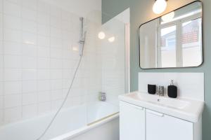 Baño blanco con lavabo y espejo en Lille Saint Maurice - Nice and functional studio en Lille