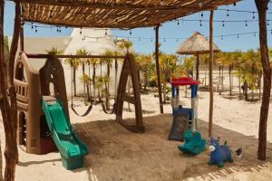 un parco giochi con scivolo e altalena incastonata nella sabbia di Villa los Nonos 4 a Mérida