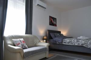 Ljubić的住宿－Apartmani DUGA，客厅配有椅子和床